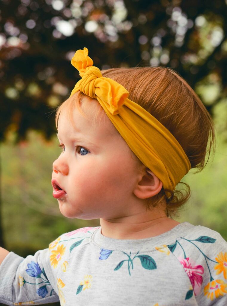 Bébé portant un bandeau jaune dans ses cheveux